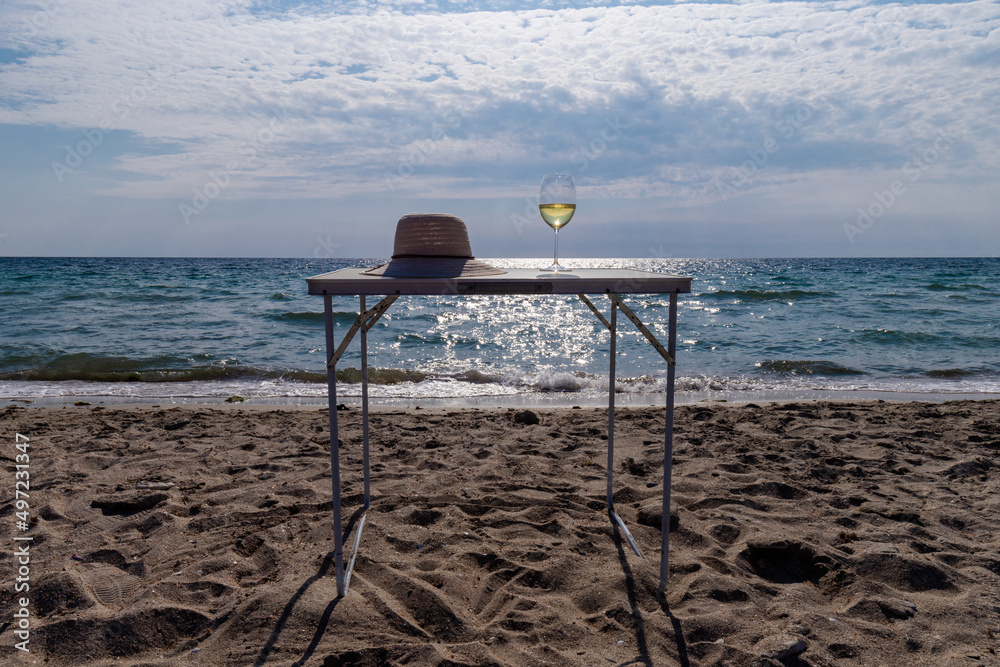 Romantic glass of white wine, on the sea beach. Wine tasting and relaxation at the resort Romantic glass of white wine, on the sea beach. Wine tasting and relaxation at the resort