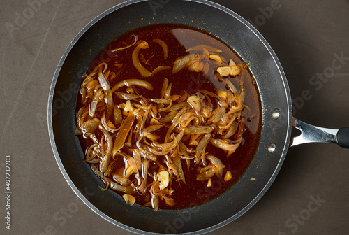 Frying pan. Poached onion with garlic, paprika and oil to prepare a rehash