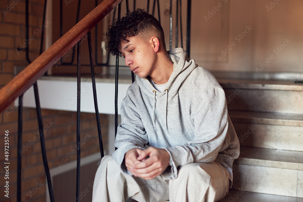 Boy sitting on stairs and leaning against railing Boy sitting on stairs and leaning against railing