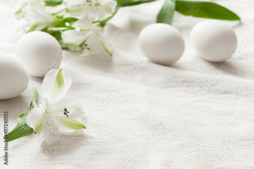 White background with white easter eggs and white spring flowers, rustic background