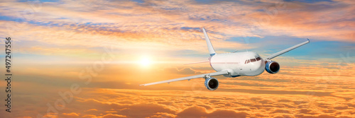 Wide panoramic view, banner of a flying passenger plane on a picturesque sunset sky, travel trip.