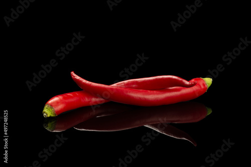 Fresh Hot red pepper isolated on a black background. Food concept. Ingredient for fresh spice Mexican food. Spicy chile cayenne pepper isolated on black background.  Dating symbol.