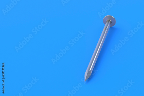One metal nail on blue background. Building equipment. Tool for repair  renovation. Copy space. 3d render