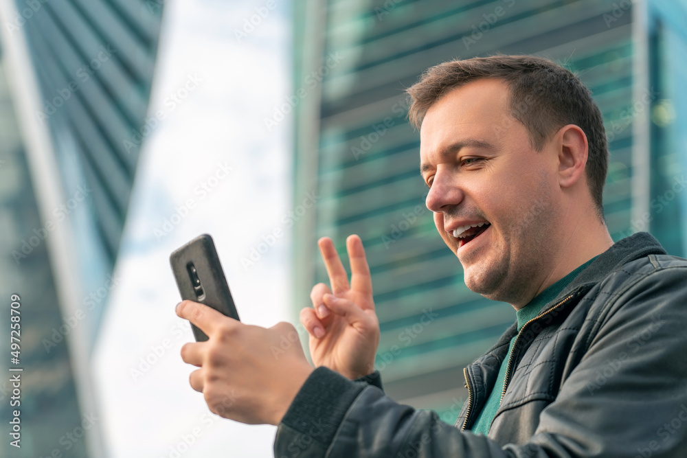 Handsome millennial man cell phone call outdoor city street. Close up portrait of happy mature guy talking on cell phone and smiling Handsome millennial man cell phone call outdoor city street. Close up portrait of happy mature guy talking on cell phone and smiling