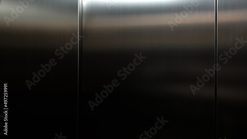 Stainless steel large sheet With light hitting the surface For background,Inside passenger elevator,Reflection of light on a shiny metal texture.