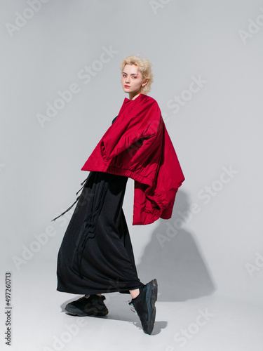 stylish blonde in a black dress with a red jacket