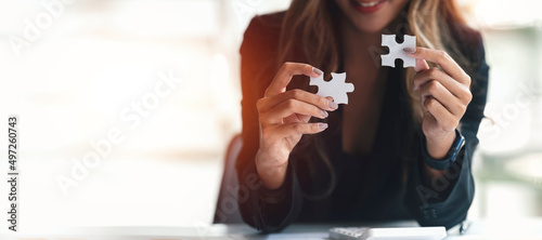 Картината върху платно Cropped shot of Businesswoman hand connecting jigsaw puzzle with sunlight effect, Business solutions, success and strategy concept, banner background