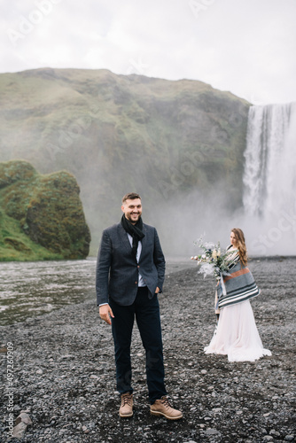 Stylish Bride and groom on elopement near Skogafoss waterfall. Iceland wedding