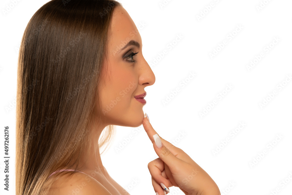 profile of a young woman touching her chin on a white background profile of a young woman touching her chin on a white background