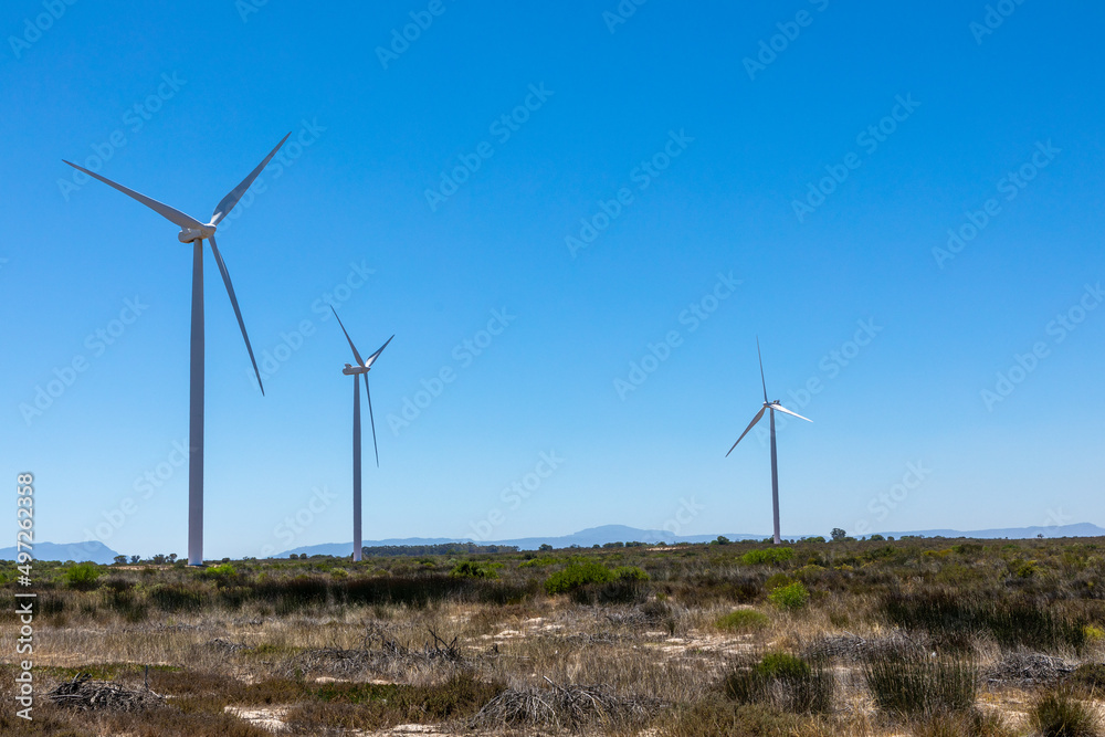 Three wind turbines against the blue sky, in an arid semi desert area Three wind turbines against the blue sky, in an arid semi desert area