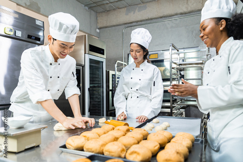 Asian Chefs baker in a chef dress and hat, cooking together in kitchen.Team of professional cooks in uniform preparing meals for a restaurant in the kitchen.