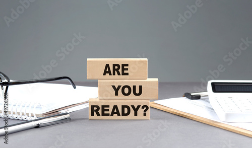 ARE YOU READY text on wooden block with notebook,chart and calculator, grey background