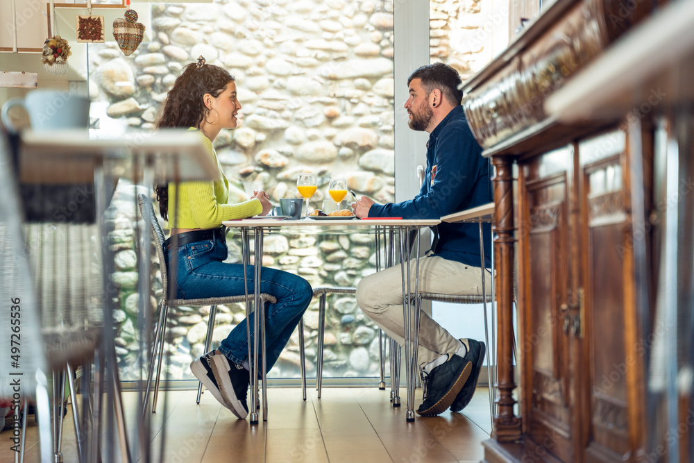 Young tourist couple talking and having breakfast in a hotel Young tourist couple talking and having breakfast in a hotel