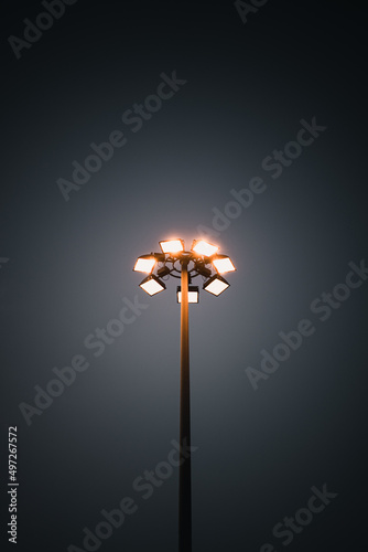Slika na platnu Vertical shot of a high mast lighting system on a dark black sky background