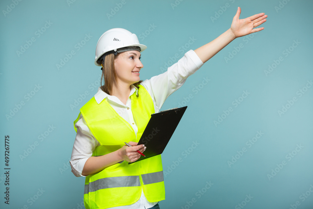 Professional engineer. A woman in a hardhat and bright jelly is using a tablet, on a blue background. Copy paste. Professional engineer. A woman in a hardhat and bright jelly is using a tablet, on a blue background. Copy paste.