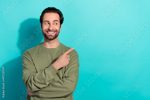 Photo of cute brunet millennial guy look promo wear green shirt isolated on teal color background © deagreez