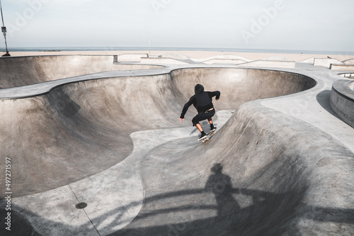 Fototapeta Naklejka Na Ścianę i Meble -  View of a boy skateboarding in a skateboard park