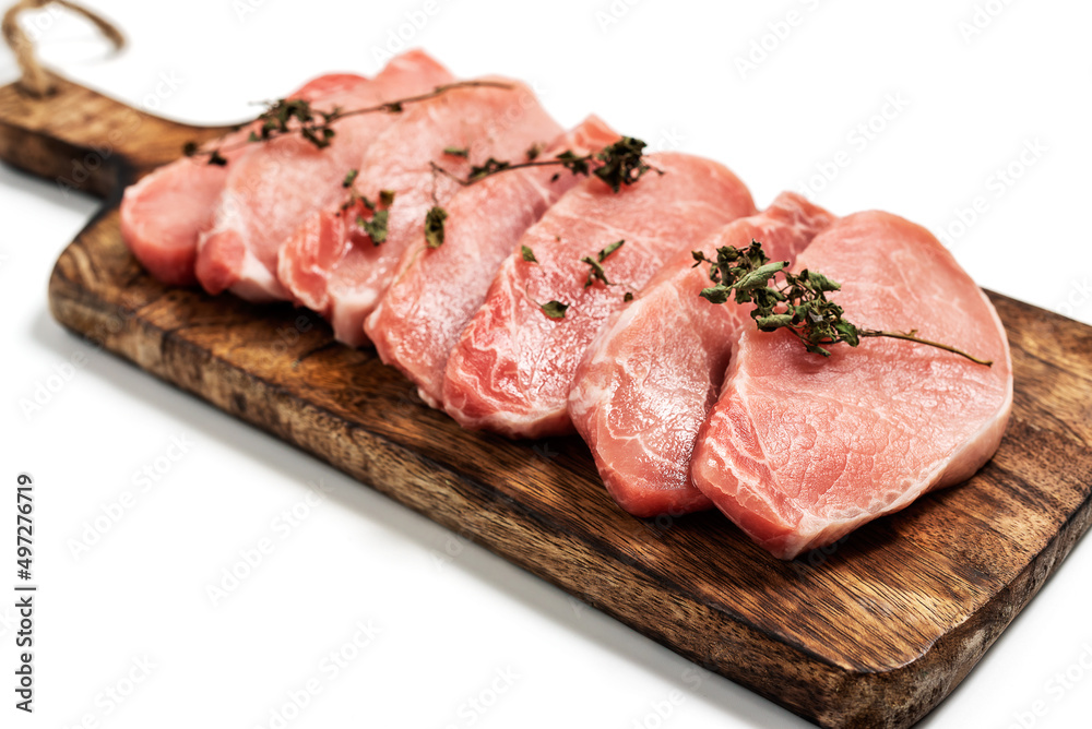 Raw pork sliced meat on wooden board on white background with dry basil leaves and spice. fresh raw beef lamb isolated on white. Heap of raw steaks Raw pork sliced meat on wooden board on white background with dry basil leaves and spice. fresh raw beef lamb isolated on white. Heap of raw steaks