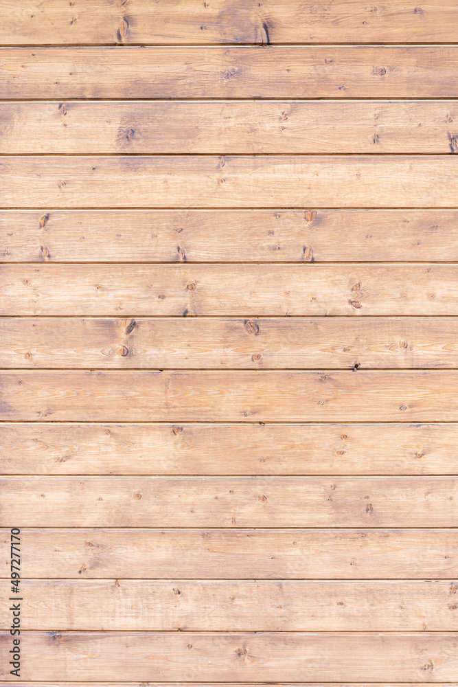 Obraz premium The polished wooden boards are fitted together. A table or fence, a wooden wall made of planks.