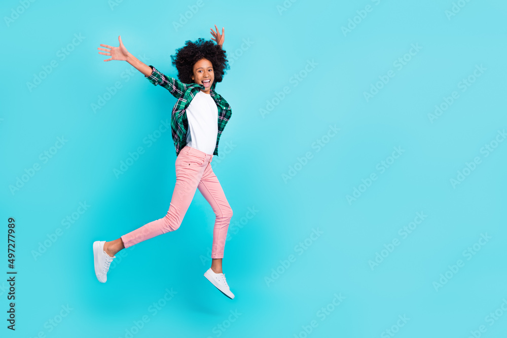 Photo of sportive crazy lady jump run raise hands wear checkered shirt isolated teal color background