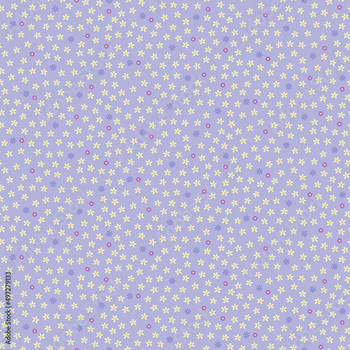 Seamless pattern of small ditsy yellow, blue and purple flowers on a lilac background.
