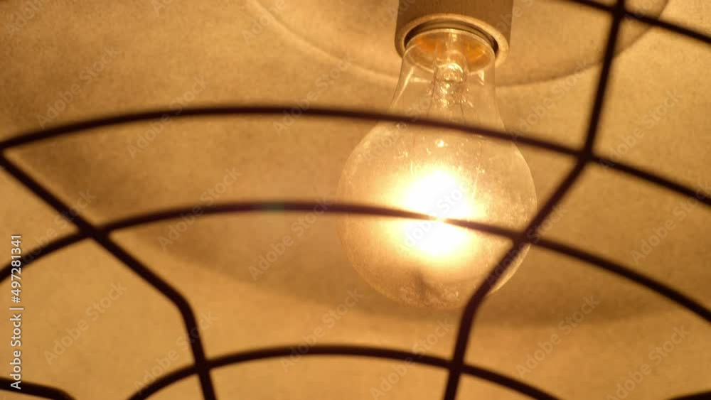 Incandescent light bulb on a ceiling lamp being turn on and off. Incandescent light bulb on a ceiling lamp being turn on and off.