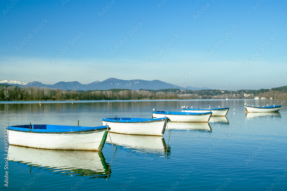 Wooden rowboats on a lake and with seagulls