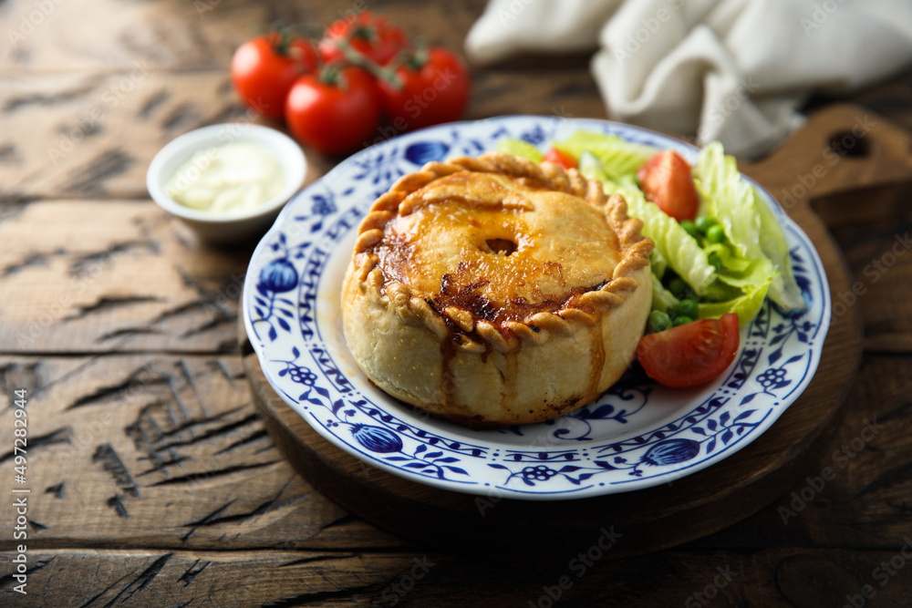 Traditional British meat pie with fresh salad Traditional British meat pie with fresh salad