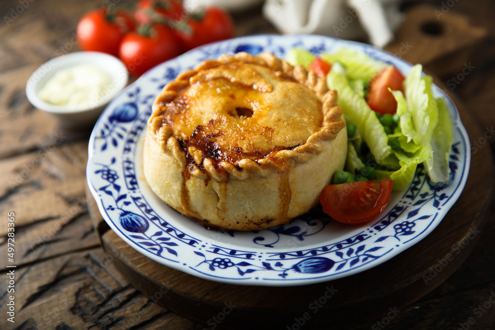 Traditional British meat pie with fresh salad Traditional British meat pie with fresh salad
