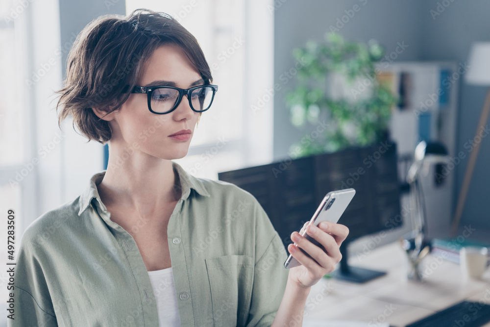 Portrait of attractive skilled focused girl tech manager using device gadget blogging typing text code at work place station indoors