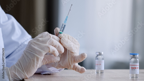 фотографія Unrecognizable doctor nurse medical worker in white coat and latex gloves holds