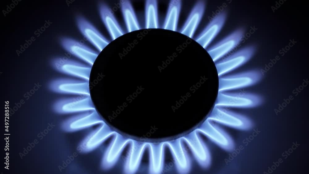 Burning gas stove hob, blue flames macro close-up in the dark on a black background. 4k raw video with smooth camera movement. Burning gas stove hob, blue flames macro close-up in the dark on a black background. 4k raw video with smooth camera movement.