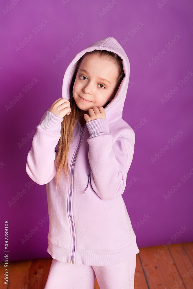Smiling, happy. Childhood and the dream of a great and famous future. Cute long-haired little girl on a purple studio background. Childhood, dreams, the concept of emotions. Smiling, happy. Childhood and the dream of a great and famous future. Cute long-haired little girl on a purple studio background. Childhood, dreams, the concept of emotions.