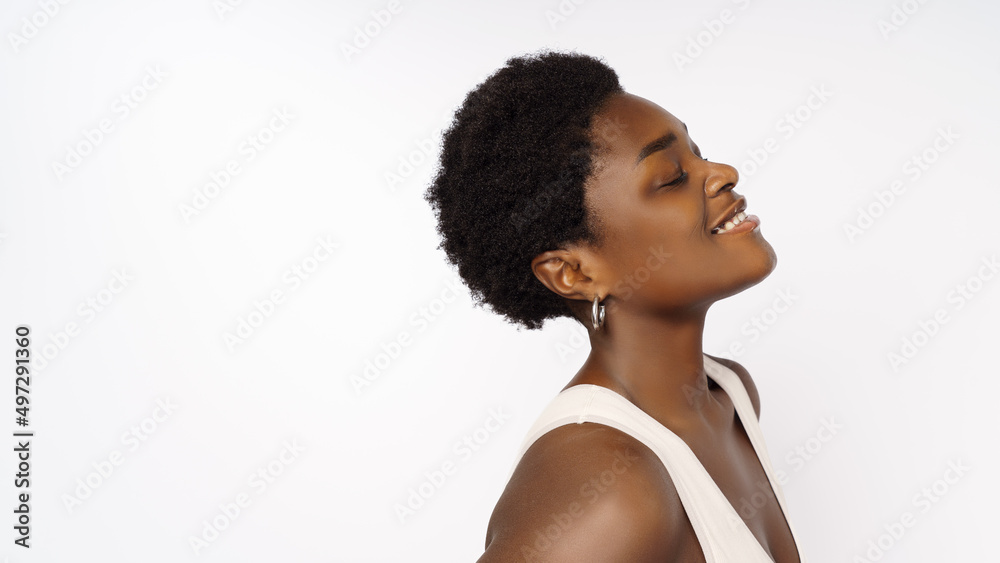 Beautiful black woman . Beauty portrait of african american woman with clean healthy skin on beige background. Smiling beautiful afro girl.Curly black hair