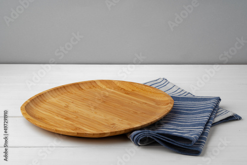 Wooden cutting board on cotton napkin on white wooden table