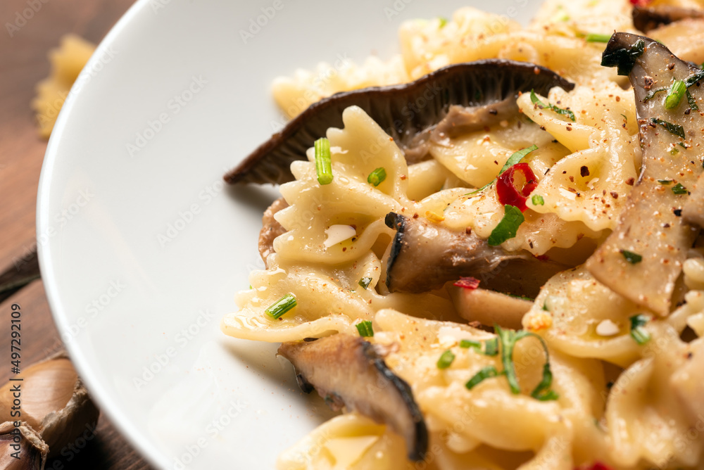 Piatto di deliziose farfalle con funghi, peperoncino, aglio e prezzemolo, Pasta Italiana 