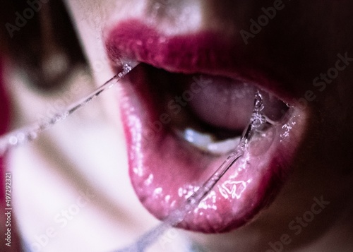 Upclose woman's mouth with saliva and red lipstick photo