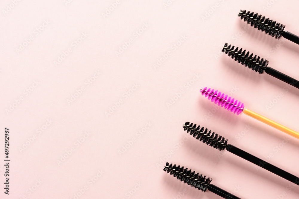 Black brushes and applicators for eyelashes and eyebrows on pink background. Womens cosmetics. Makeup for the face. Black brushes and applicators for eyelashes and eyebrows on pink background. Womens cosmetics. Makeup for the face.