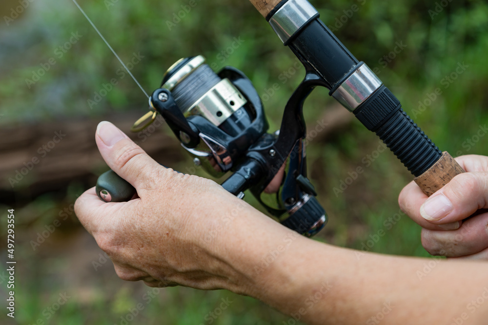 Close-up of a woman's hand on a fishing rod. Close-up of a woman's hand on a fishing rod.