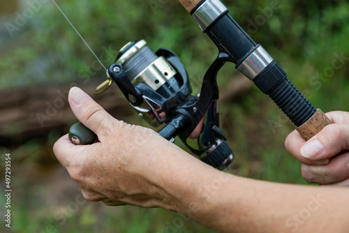 Close-up of a woman's hand on a fishing rod.