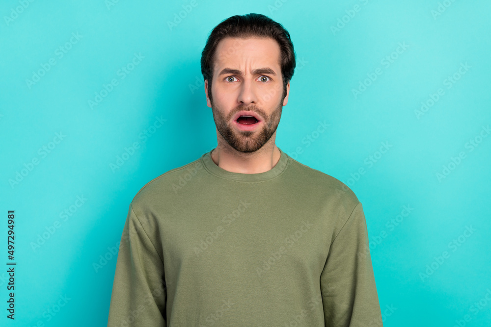 Fototapeta premium Photo of stressed brunet millennial guy open mouth wear green pullover isolated on teal color background