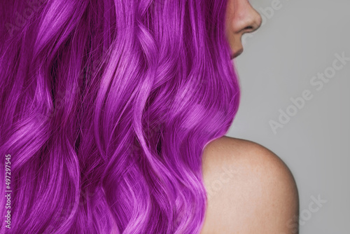 Foto Close-up of the wavy hot purple hair of a young woman isolated on a gray background