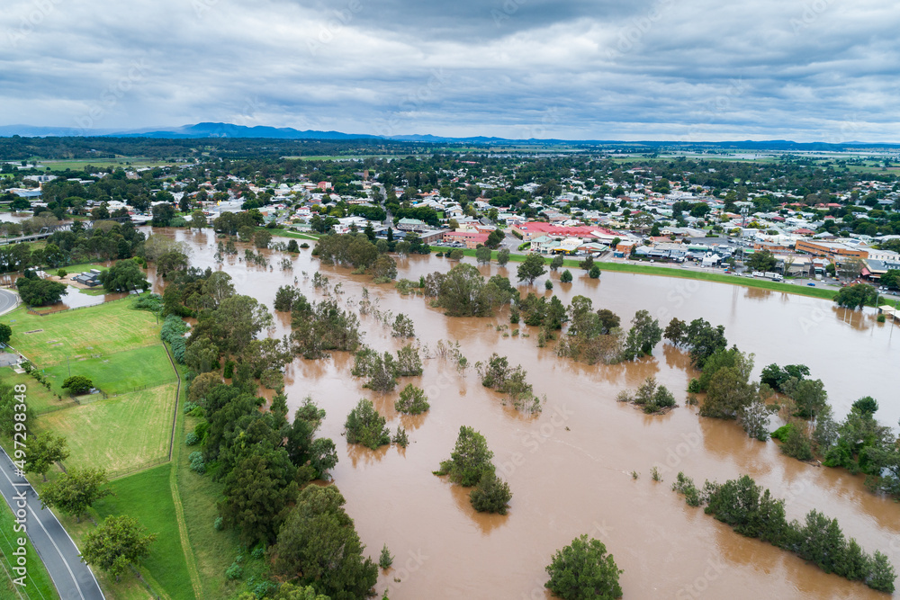 Flooding river with floodwaters reaching up the levee bank Flooding river with floodwaters reaching up the levee bank