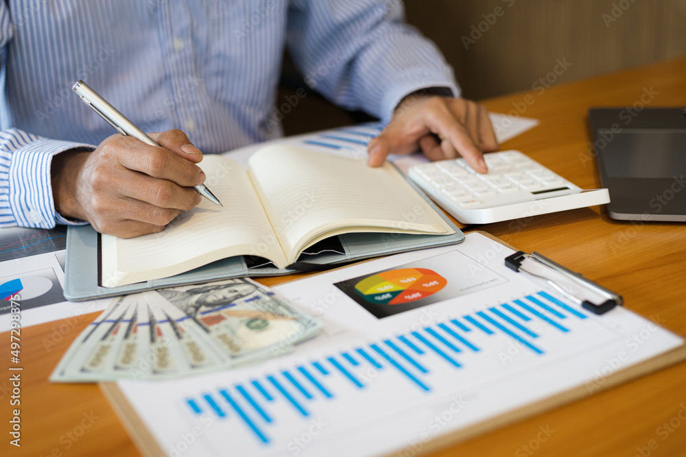 Businessman doing calculations using calculator and writing notes. Accounting Concepts and Personal Financial Planning Businessman doing calculations using calculator and writing notes. Accounting Concepts and Personal Financial Planning