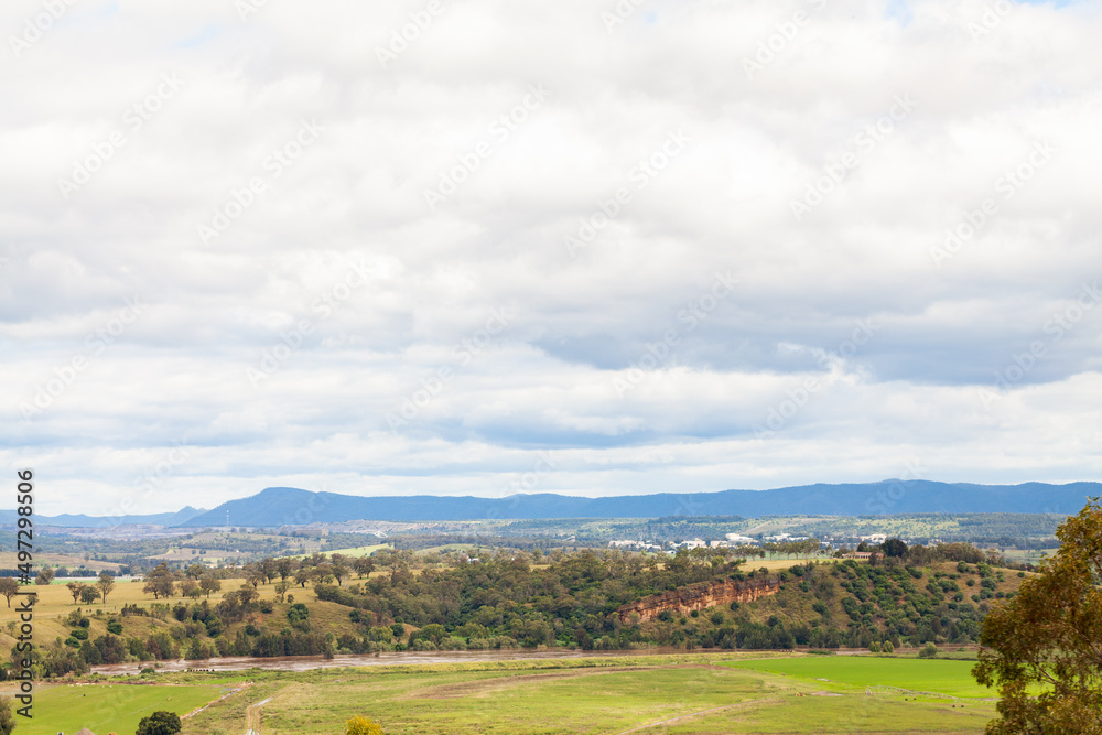Cloudy sky with cliff and flooding river below