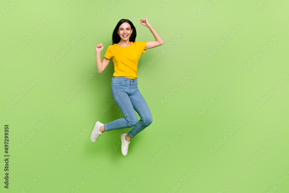 Full length portrait of excited crazy girl raise fists celebrate accomplishment isolated on green color background