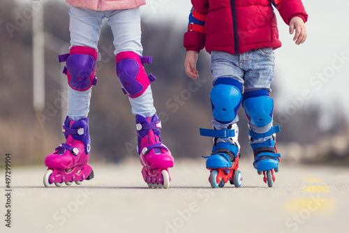 Canvas Print Kids boy and girl having fun outdoor while riding roller skates