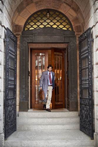 Heading home at the days end. A view of a businessman leaving work through an ornate doorway. © Alexandra/peopleimages.com