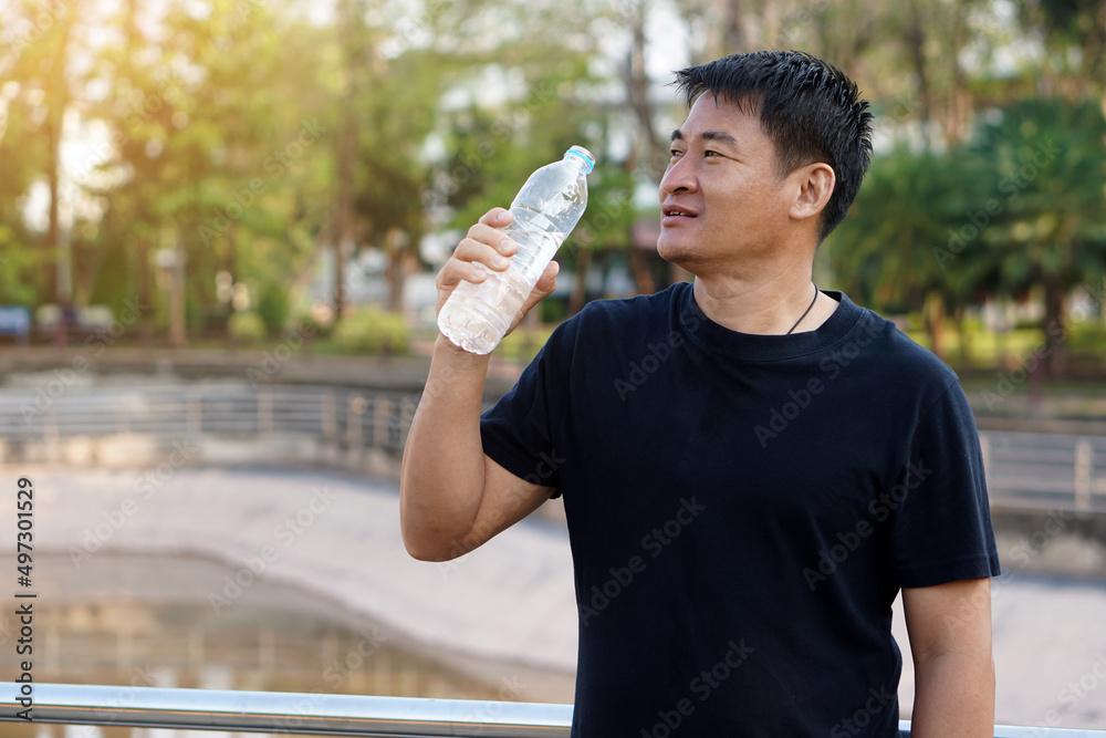 Happy Asian man holds bottle of drinking water to drink, stands at the park. Concept : Drink water for health.
Healthy lifestyle. Happy Asian man holds bottle of drinking water to drink, stands at the park. Concept : Drink water for health.
Healthy lifestyle.
