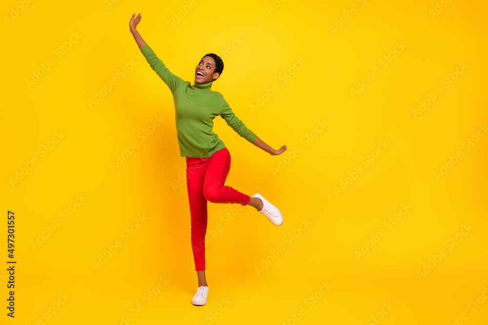 Photo of pretty sweet trans woman wear green turtleneck dancing empty space isolated yellow color background